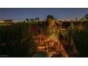 An expansive backyard view featuring a private pool, lush landscaping, and scenic city lights beyond at 3412 Crystal Tower St, Las Vegas, NV 89129