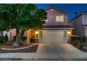 Charming two-story home featuring manicured landscaping and a two-car garage at twilight at 3412 Crystal Tower St, Las Vegas, NV 89129