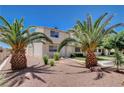 Inviting two-story home featuring desert landscaping with rocks, mature palm trees, and well-manicured shrubbery at 4693 Mill Valley Dr, Las Vegas, NV 89120