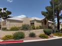 Beige single-story home with a desert landscape, wrought iron fence, and terracotta-style roof at 471 Fallwood Ln, Las Vegas, NV 89107