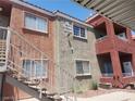 Exterior view of multi-story condo building featuring tan and red stucco at 4730 E Craig Rd # 1155, Las Vegas, NV 89115