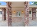 Covered patio with brick columns leading to double doors, creating a welcoming outdoor space at 4805 Jay Ave, Las Vegas, NV 89130
