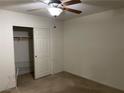 Standard bedroom with closet featuring a wooden ceiling fan, bare carpet, and no decor at 5334 Floating Flower Ave, Las Vegas, NV 89139