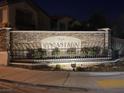 Stone community sign reading 'North Encantada' with decorative wrought iron fence and desert landscaping at night at 5334 Floating Flower Ave, Las Vegas, NV 89139