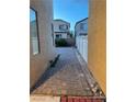 Paver side yard with a brick path and white fence dividing two houses, offering a clean outdoor space at 5334 Floating Flower Ave, Las Vegas, NV 89139