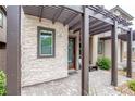 Charming front entrance with stone accents, a pergola, and a neatly paved walkway leading to the front door at 541 Tokopah Falls St, Las Vegas, NV 89138