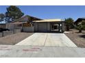 Street view of a distressed single-story house with desert landscaping, a two-car garage, and significant damage needing repair at 6723 Oak Valley Dr, Las Vegas, NV 89103