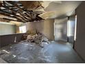 A gutted living room reveals exposed rafters, debris, and the need for extensive renovations at 6723 Oak Valley Dr, Las Vegas, NV 89103