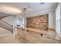Beautiful living area featuring tiled flooring, stone accent wall, breakfast bar, and staircase at 7095 Mountain Den Ave, Las Vegas, NV 89179