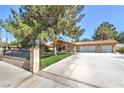 Beautiful home showcasing lush landscaping, a tile roof, and an expansive driveway with 3-car garage at 7460 Buckskin Ave, Las Vegas, NV 89129