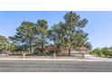 Charming single-story home with lush landscaping, desert landscaping, a tile roof, and a rod iron fence at 7460 Buckskin Ave, Las Vegas, NV 89129