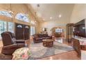 Open living room boasts a high ceiling, a cozy fireplace, and an abundance of natural light at 7460 Buckskin Ave, Las Vegas, NV 89129