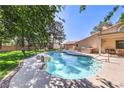 Serene backyard featuring a sparkling swimming pool, built-in grill and a covered patio for outdoor relaxation at 7460 Buckskin Ave, Las Vegas, NV 89129