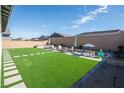 Expansive backyard featuring artificial turf, a large patio area, and an outdoor dining set at 832 Canonbury St, Henderson, NV 89011