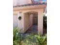 Covered front porch featuring neutral colored stucco and manicured tropical landscaping at 9365 Sparkling Waters Ave, Las Vegas, NV 89129