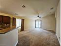 Spacious living room featuring neutral carpet, ceiling fan, and sliding glass door access at 9462 Alhambra Valley St, Las Vegas, NV 89178