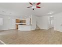 Open-concept living room featuring wood-look floors, lots of light, and access to the kitchen and stairs at 9535 Stills Way, Las Vegas, NV 89148