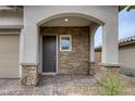 Welcoming entryway featuring stone accents, an arched porch, and a stylish front door at 9876 Heather Moore Ave, Las Vegas, NV 89166