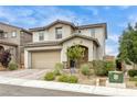 Inviting two-story home with a paved driveway, two-car garage, and beautifully landscaped front yard at 9876 Heather Moore Ave, Las Vegas, NV 89166