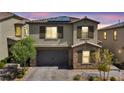 Two-story home boasts a neutral color palette, stone accents, and a two-car garage with an attractive brick paver driveway at 10116 Skye Castle Dr, Las Vegas, NV 89166