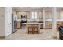 Spacious eat-in kitchen featuring an island with seating, stainless appliances, and tile flooring at 1017 Pebble Lake St, Henderson, NV 89011
