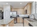 Bright kitchen with an island, stainless steel appliances and light wood cabinets at 1017 Pebble Lake St, Henderson, NV 89011