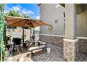 Cozy backyard patio includes a unique table and umbrella for shade at 1017 Pebble Lake St, Henderson, NV 89011