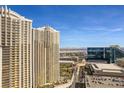 View of the condo's exterior with the Las Vegas skyline in the background and community pool below at 135 E Harmon Ave # 3816, Las Vegas, NV 89109