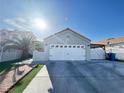 Exterior view of a one-story home featuring a two-car garage and well-maintained landscaping at 1505 Lilac Breeze Cir, Las Vegas, NV 89108