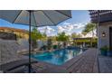 Inviting pool with pergola and a view of the beautiful backyard on a sunny day at 1869 Bronze Patina St, Henderson, NV 89044