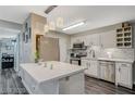 Modern kitchen with white cabinets, stainless appliances, updated lighting and a beautiful backsplash at 2451 N Rainbow Blvd # 2076, Las Vegas, NV 89108