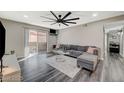 Bright living room with modern gray tones, plank flooring, a large fan, and access to the outdoor patio at 2451 N Rainbow Blvd # 2076, Las Vegas, NV 89108