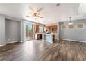 An open-concept area with modern ceiling fan, view to kitchen and sliding glass door to backyard at 28 Yellow Flame Ave, North Las Vegas, NV 89084