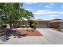 Charming single-story home featuring manicured landscaping, a spacious driveway, and a neutral color scheme at 5586 Golden Leaf Ave, Las Vegas, NV 89122