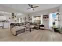 Bright living room features a large gray sofa, ceiling fan and natural light at 6108 Shallow Springs St, Las Vegas, NV 89130