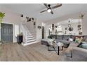 Open-concept living room with a staircase and wood flooring, perfect for entertaining at 6108 Shallow Springs St, Las Vegas, NV 89130