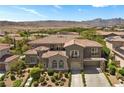 An elegant home with a clay tile roof and large two-car garage sits on a well-landscaped lot in a mountain community at 631 Coriander Canyon Ct, Las Vegas, NV 89138