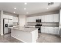 Modern kitchen featuring white cabinetry, stainless steel appliances, granite countertops and a large island at 7733 Rosebark Cliffs St, North Las Vegas, NV 89084