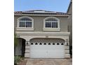 Two-story home featuring a two-car garage and a charming facade with arched windows and solar panels at 8116 Russell Creek Ct, Las Vegas, NV 89139