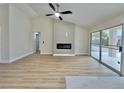 Open-concept living area with modern fireplace, wood-look floors, and sliding doors leading to an outdoor space at 8513 Festival Dr, Las Vegas, NV 89134