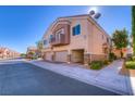 Townhome features three-car garage, desert landscaping, and an upper-level balcony at 8717 Tom Noon Ave # 101, Las Vegas, NV 89178