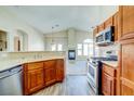 Open kitchen with wood cabinets, stainless steel appliances, and eat-in bar for casual dining at 8717 Tom Noon Ave # 101, Las Vegas, NV 89178