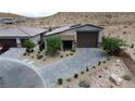 An aerial view of the home with a desert landscape, lovely backyard, and beautiful stone driveway at 9570 Thistle Creek Ave, Las Vegas, NV 89178