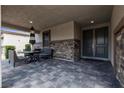 A covered outdoor patio with stone accents, a black patio set, and recessed lighting at 9570 Thistle Creek Ave, Las Vegas, NV 89178