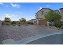 Charming home exterior featuring a manicured front yard and a spacious brick driveway at 9654 Starfish Reef Way, Las Vegas, NV 89178