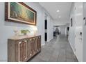 Elegant home hallway with tile floors, decorative console table and artwork at 9654 Starfish Reef Way, Las Vegas, NV 89178