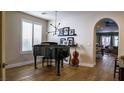 Elegant living room features a grand piano, modern lighting, and hardwood floors at 11731 Longworth Rd, Las Vegas, NV 89135