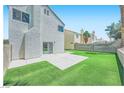 An exterior shot of a backyard with a concrete patio and artificial grass for easy maintenance at 1501 Lucia Dr, Las Vegas, NV 89128