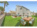 Spacious backyard with outdoor seating area, lush lawn, and a fire pit for entertaining at 1501 Lucia Dr, Las Vegas, NV 89128