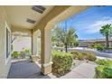 Inviting front porch with stone pillars, verdant landscaping, and a view of the neighborhood at 1941 Williamsport St, Henderson, NV 89052